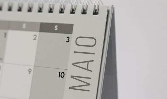 A close-up of a spiral-bound desk calendar emphasizing the month of May.